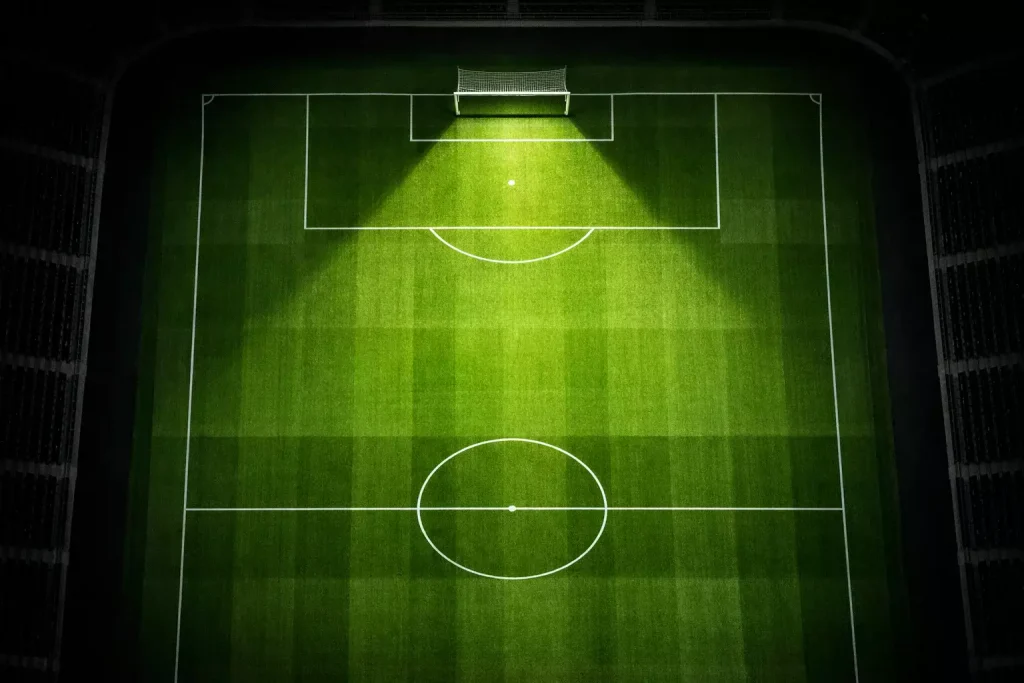 Campo de fútbol visto desde arriba con líneas tácticas y zonas de disparo iluminadas en un estadio profesional