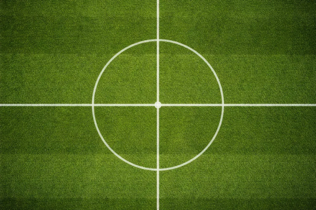 Dos mitades de un campo de fútbol con césped natural vistas desde la línea central